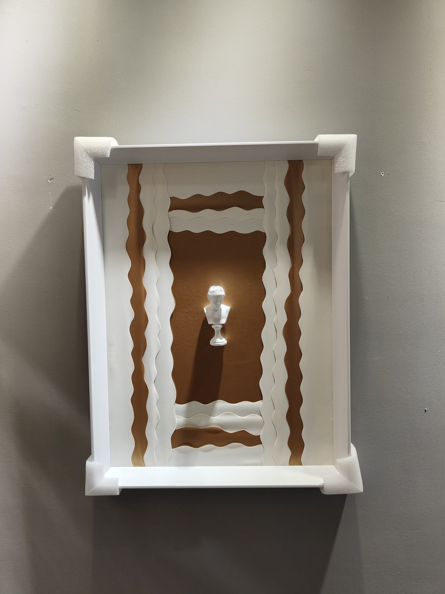 Sculptural relief wall art with classical bust in brown and white tones